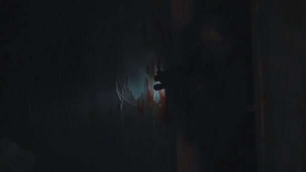 Солдат в защитном шлеме смотрит в поле зрения на оружие с фонариком в темноте — стоковое видео