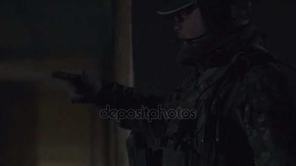 Man soldier in military uniform talking with colleague in dark building — Stock Video