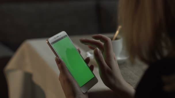 Donna mani toccando sullo schermo verde cellulare sullo sfondo tazza di caffè — Video Stock