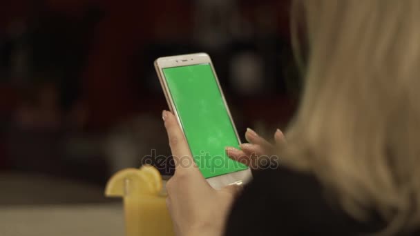 Mujer manos tocando en la pantalla verde del teléfono móvil en el jugo de fondo de vidrio — Vídeos de Stock