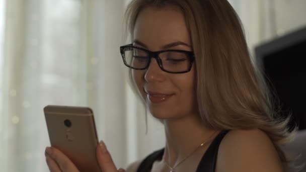 Femme dans des lunettes à l'aide d'un téléphone mobile sur fond tasse à café à table dans un café — Video