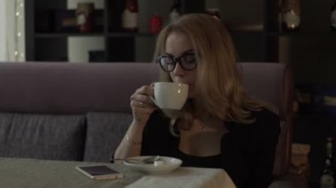 Modern kafede masada fincan kahve içme gözlük güzel kadın