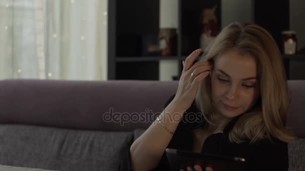 Wanita cantik melihat di layar tablet pc duduk di sofa di kafe — Stok Video