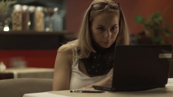 Mujer joven mirando en la pantalla portátil y leyendo noticias en las redes sociales — Vídeo de stock