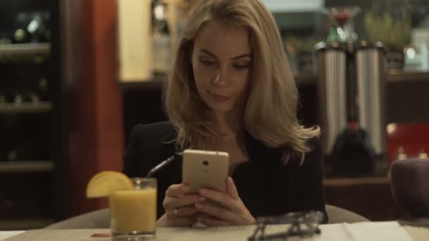 Jonge vrouw in glazen roepend door mobiele telefoon aan tafel in café — Stockvideo