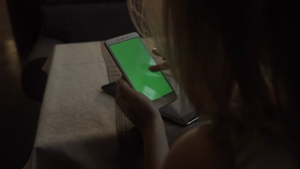 Manos femeninas tocando el teléfono móvil de pantalla verde en el fondo zumo de naranja — Vídeos de Stock