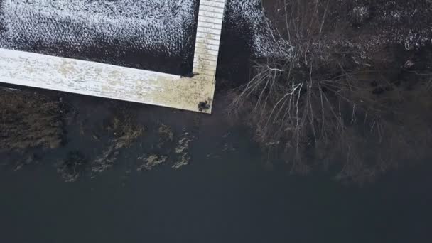 Vista aérea pescador sentado en el muelle del río con caña de pescar mordida de espera — Vídeos de Stock