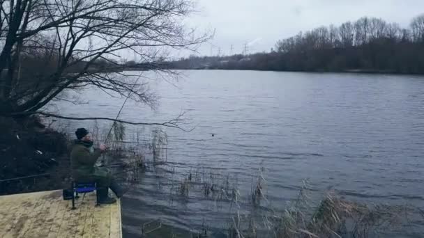 Dron Zobacz rybak siedzi na molo nad rzeką z wędką oczekiwania bite — Wideo stockowe