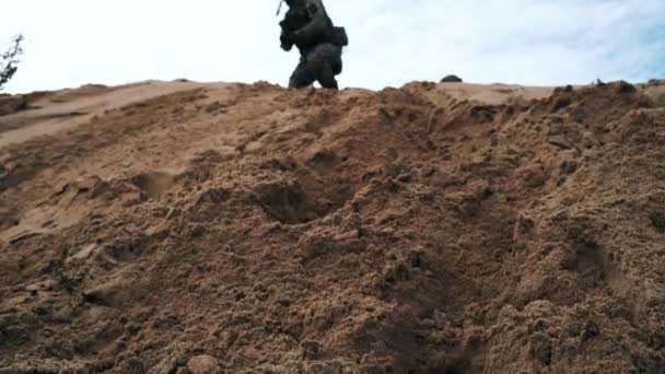 Militära soldater med vapen striderna i öknen. Soldater som körs på sand — Stockvideo