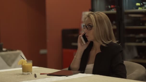 Ung kvinna talar med mobiltelefon och skriva meddelande på skärmen tablet PC — Stockvideo