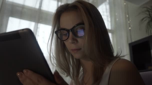 Hermosa mujer que utiliza la tableta moderna PC y la pantalla que refleja en gafas — Vídeos de Stock