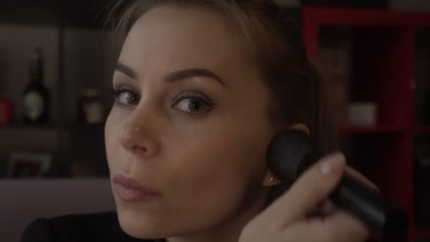 Красива жінка використовує косметичний пензлик для рум'ян і порошку для макіяжу обличчя — стокове відео