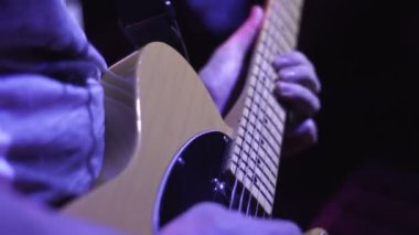Rock müzisyeni solo müzik konserinde karanlık sahne alanı'nda elektro gitar üzerinde çalış