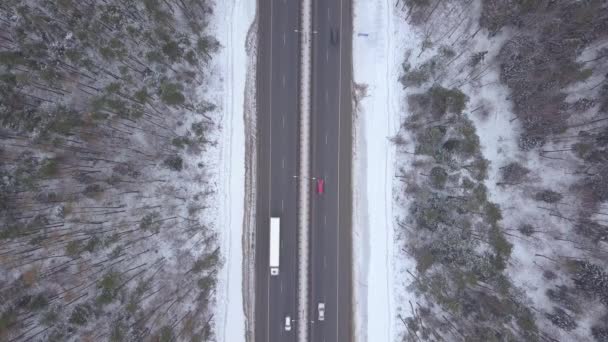 Topo do tráfego de carros vista na estrada de inverno. Carros e caminhões dirigindo na estrada de inverno — Vídeo de Stock