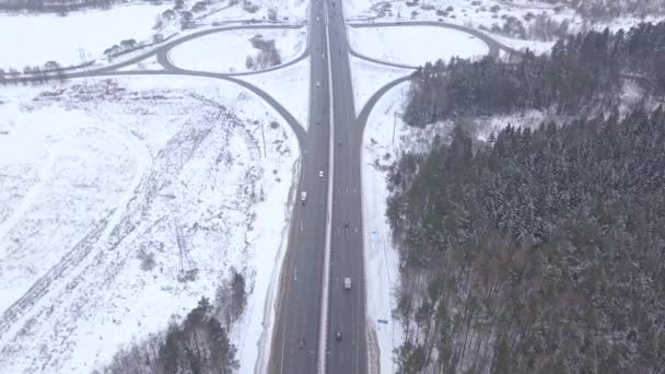 Légi fényképezés repülő bordó autó mozog a téli autópálya kereszteződés — Stock videók