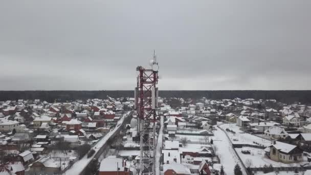 Vysoké vysílací věž s televize a mobilní antény v zimě letecký pohled na obec. DRONY rozhledna komunikační antény pro rádio a mobilní vlnu. — Stock video