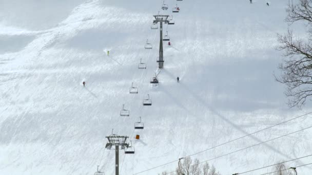 Skifahren und Snowboarden auf dem Schneehang im Winterskigebiet. Skilift auf dem Schneeberg. Winteraktivität im Skigebiet. — Stockvideo