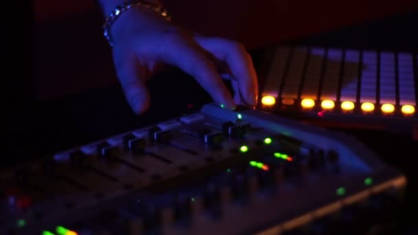 Disque jockey masculin sur console de mixage pour mixer de la musique sur disco party. Man dj joue de la musique sur une console audio dans une boîte de nuit. Panneau de jockey de disque et pont de mélange avec éclairage coloré . — Video