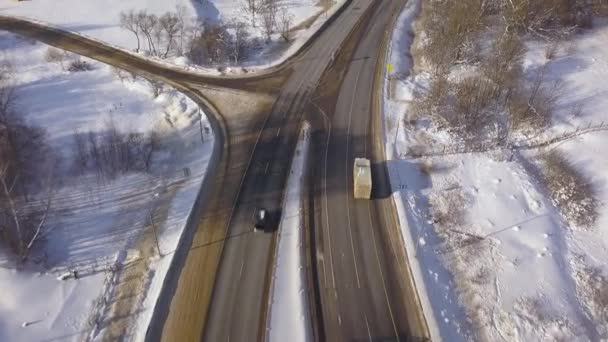 Car and cargo truck moving on winter highway view from above flying drone. Aerial view car traffic on snowy road on winter landscape. — Stock Video