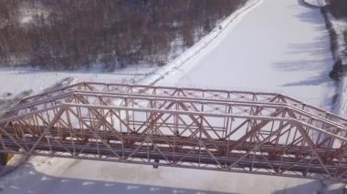 Üstten Görünüm asma demiryolu Köprüsü tren hareket kış manzara donmuş nehir üzerinde için. Havadan görünümü tren Köprüsü aracılığıyla kış nehir.
