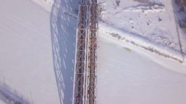 Demiryolu Köprüsü karlı manzara dron görünümünde kış nehir üzerindeki tren trafik için. Süspansiyon tren Köprüsü aracılığıyla kış nehir ve demiryolu parça havadan görünümü.
