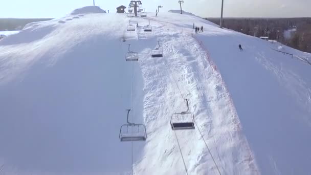 People skiing on snow slope on winter vacation at ski resort aerial view. Ski elevator fro skiing and snowboarding. Winter activity on snow mountain on drone view. — Stock Video