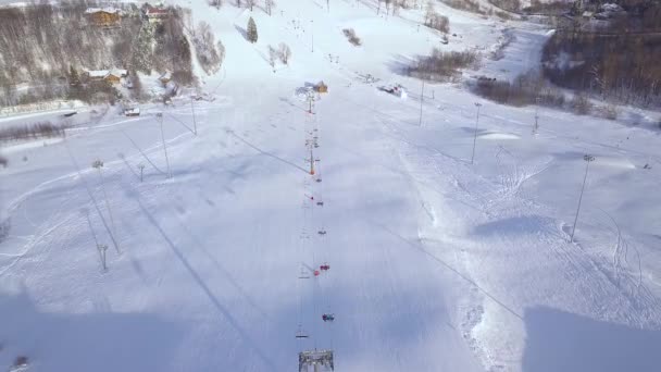 Paisagem aérea encosta de neve com elevador de esqui no resort de esqui de inverno. Atividade de inverno na vista drone resort de esqui de luxo . — Vídeo de Stock