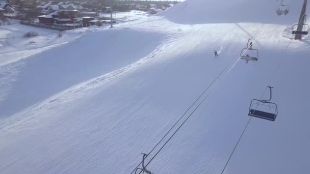 Man skidåkning på snö berg i winter ski resort Flygfoto. Ski semester och vinter sport på snö backen i luxury resort drönarvy. Vintern skidåkning på snöiga berg. — Stockvideo