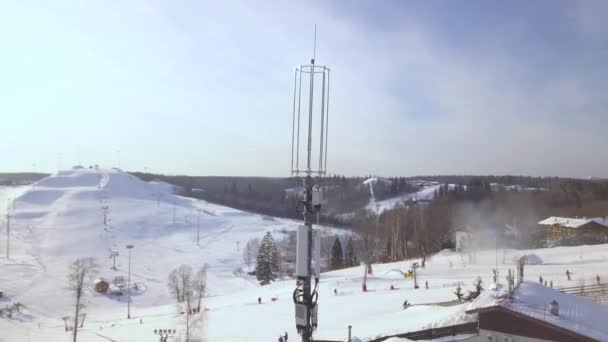 Torre alta con antenas para olas móviles en estación de esquí de invierno. Drone ver la antena repetidor de comunicación del teléfono móvil. Antena de red de telefonía móvil . — Vídeo de stock