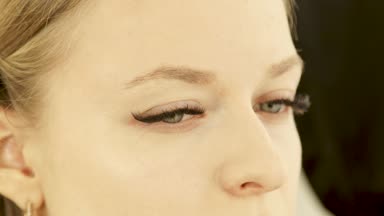 Kadar genç kadın yüz makyaj kozmetik sünger ile cilt güzellik stüdyosu üzerinde uygulama sırasında kapatın. Yüzey tonu düzeltme soyunma odasında için profesyonel makyaj.