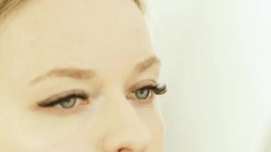 Kadın makyaj sanatçı uygulanan sesi krem kozmetik sünger cilt yüz güzellik modeli ile kapatın. Profesyonel salon yüzüne makyaj sırasında genç kadın portre.