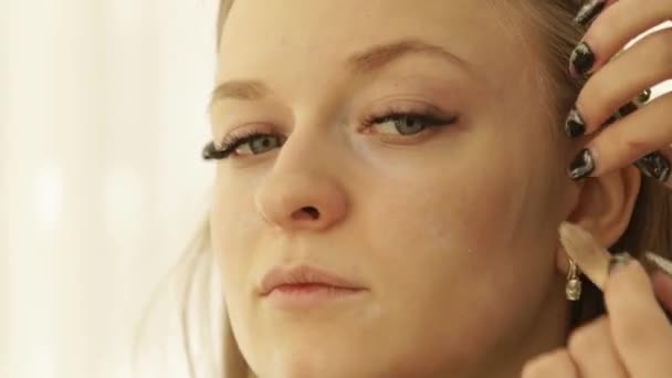 Close up rosto jovem mulher durante a aplicação de maquiagem com escova cosmética na pele. Visagiste aplicando creme de tom no modelo de beleza da pele durante a aula de maquiagem na escola de beleza . — Vídeo de Stock