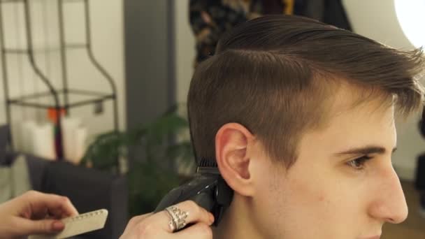 Cabeleireiro masculino corte de cabelo com cortador de cabelo na barbearia de perto. Cortador de cabelo fazendo homens corte de cabelo com navalha elétrica no salão de cabeleireiro . — Vídeo de Stock