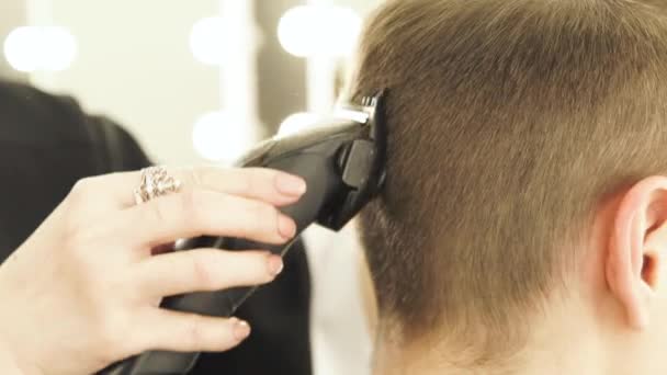Kvinna Frisör klippa manligt håravfall med rakapparat i skönhetsstudio. Närbild av manliga frisyr med hårklipparen i barbershop. Kvinna hairdcutter arbetar med klient. — Stockvideo