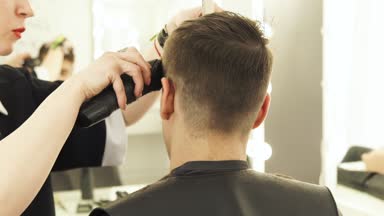 Saç kesme makinesi ile kesme ve güzellik salonunda tarak erkek saç yapma Haircutter kapatın. Profesyonel saç modeli ile Elektrikli tıraş makinesi yapıyor Kuaför.