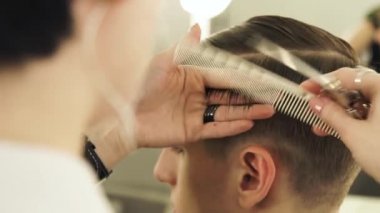 Saç tarama ve profesyonel makasla kesme kadın Kuaför kapatın. Erkek saç tarak ve kuaförlük makasla yapıyor Haircutter.