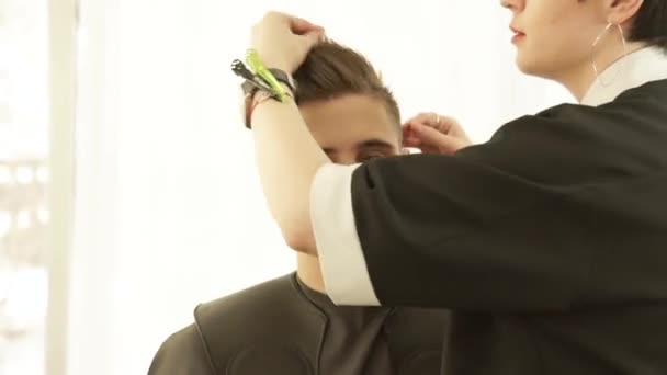 Cabeleireiro fazendo estilo de cabelo masculino após o corte e secagem no salão de cabeleireiro. Estilo de cabelo profissional após cabeleireiro no estúdio de beleza . — Vídeo de Stock