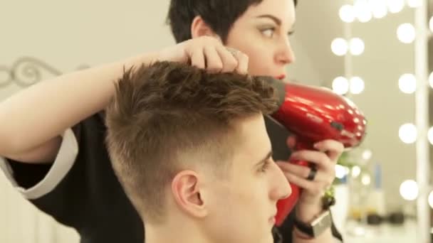 Asciugatura parrucchiere e styling dei capelli maschili dopo il taglio nel salone di parrucchiere. Close up parrucchiere styling capelli con asciugatrice dopo il lavaggio. Finire parrucchiere in studio di bellezza . — Video Stock