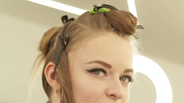 Beautiful woman with clamp for fixing long hair during haircutting in hairdressing salon. Close up portrait woman hair model in beauty studio. — Stock Video