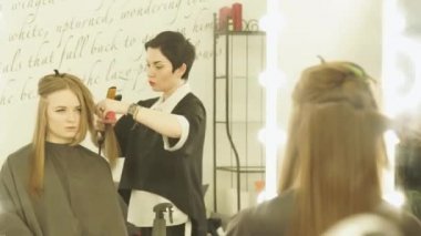 Kuaför Saç maşa ve saç güzellik salonunda düzleştirme için tarak saç modeli yapmak. Upfemale Kuaför uzun saç düzleştirme kapatın. Kuaförlük salonda kadın saç şekillendirme.