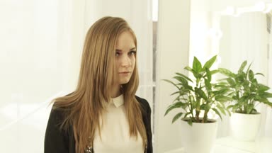 Portre fotoğraf makinesi ve çevresinde döndürme bakarak uzun saçlı güzel kadın. Studio genç kadın yüz kadar kapatın.