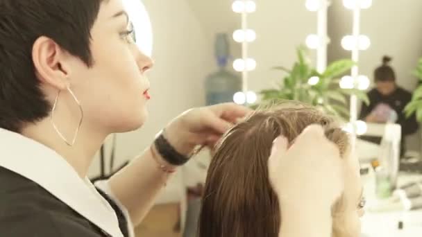 Friseurin macht Massage Kopf junge Frau im Friseursalon. Nahaufnahme Friseur arbeitet mit Klient im Schönheitssalon. — Stockvideo