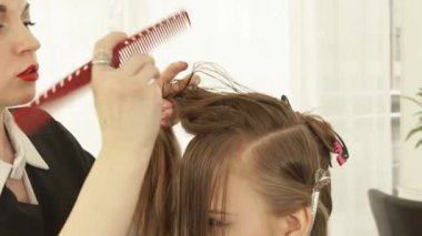 Kuaförlük salonda kadın saç kesimi sırasında uzun saç tarama Haircutter. Kadın saç güzellik salonda kapatın. Kuaför kadın müşteri ile çalışma.