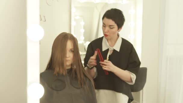 Peluquero peinando y cortando pelo largo con tijeras en peluquería. Peluquería de cerca haciendo corte de pelo de mujer con tijeras en el estudio de belleza . — Vídeos de Stock