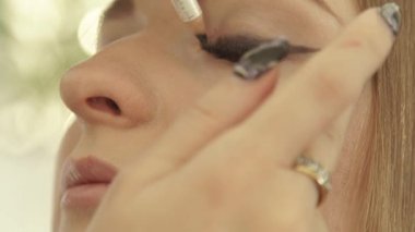 Göz kapağı kapalı gözler kadınla siyah eyeliner dokunmadan makyaj sanatçısı. Göz kalemi kalem için makyaj gözleri okları kullanarak visagist kadar kapatın.