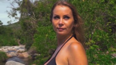 Tropikal orman nehri arka planında bikinili seksi beyaz kadın portresi