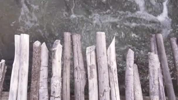 Vista dall'alto verso il basso dell'acqua frizzante che scorre sotto un ponte di legno nel fiume . — Video Stock