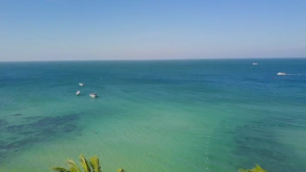 Luftaufnahme eines ruhigen blauen Ozeans mit Segelbooten und tropischen Palmen. — Stockvideo