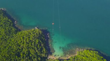 Tramvayların tropik adalarda seyahat edişinin ve geçişinin insansız hava aracı görüntüsü mavi okyanus.
