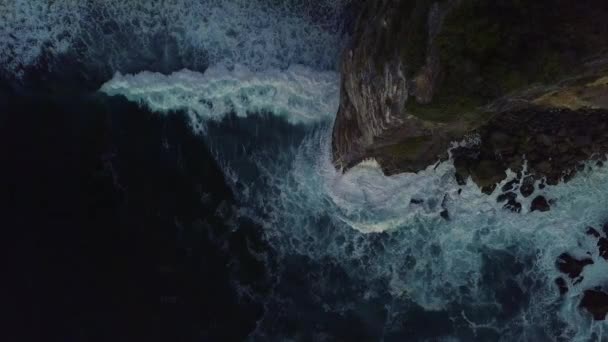 Top view at rock cliff with big foamy ocean waves shattering against the coast — Stock Video
